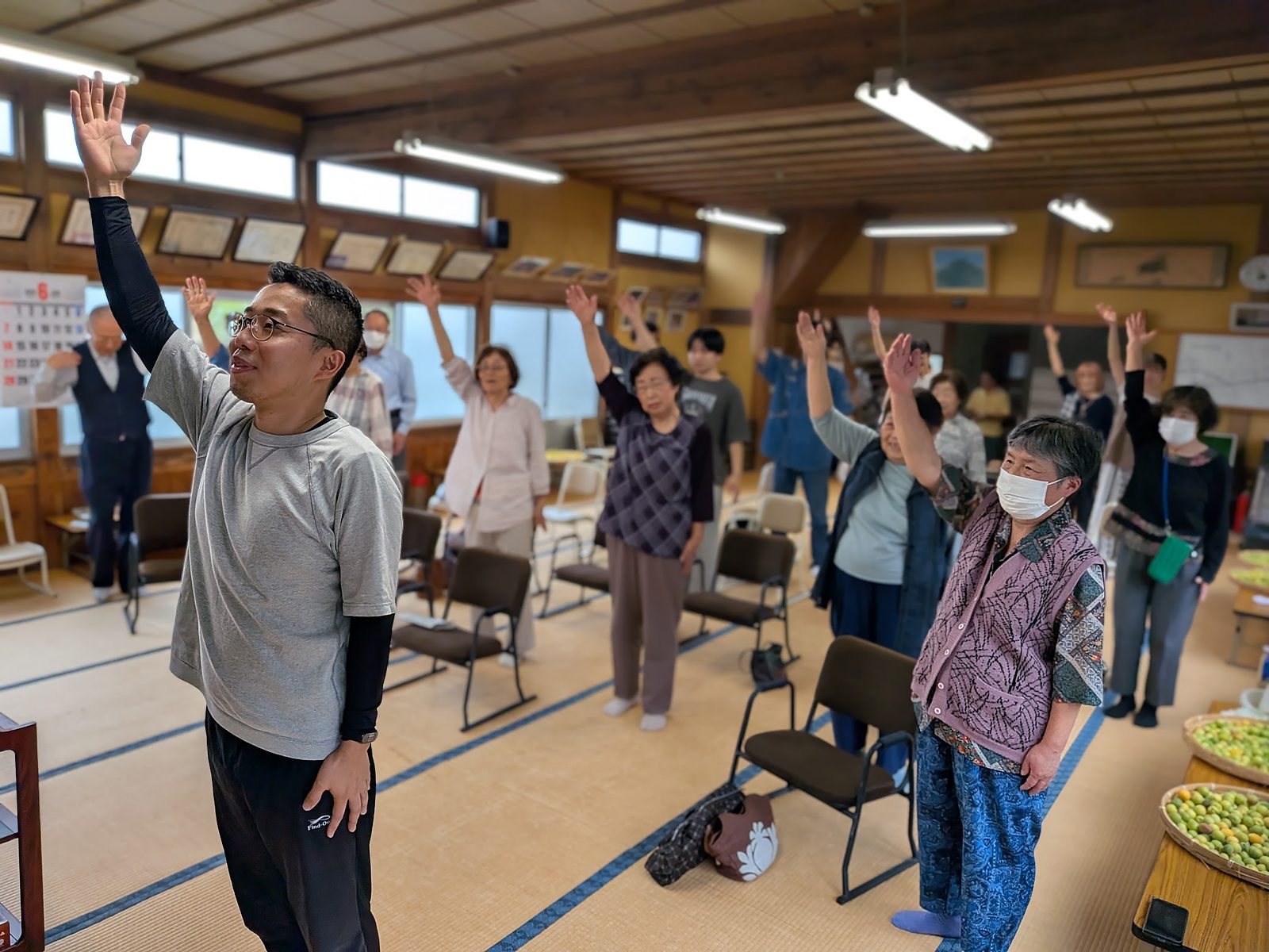 平清水公民館での活動の様子。参加者が手を挙げて体を動かしている